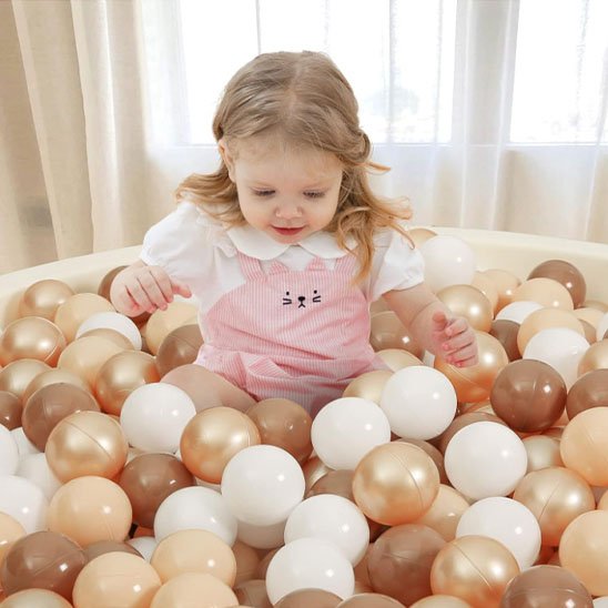 Balle piscine a balle brune beige enfant dedans
