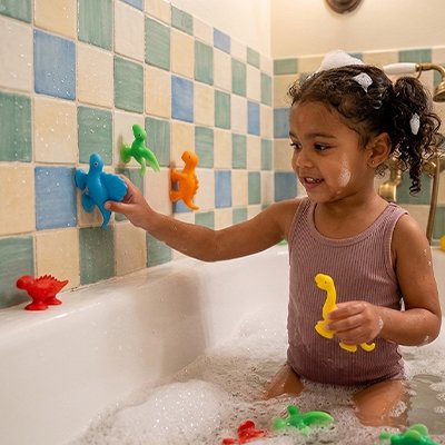 Jouet de bain fillette joue avec dinosaure