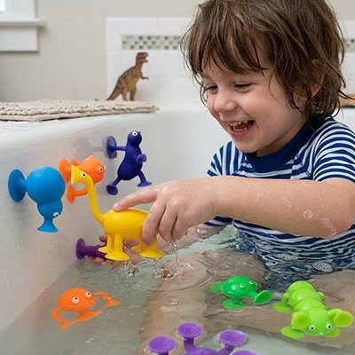 Jouet de bain multicolore enfant assit dans l'eau